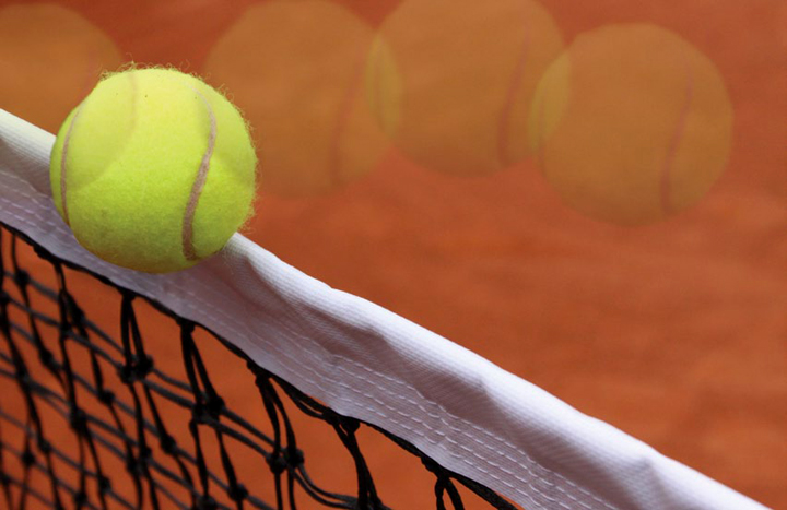 Tennis ball flies over net