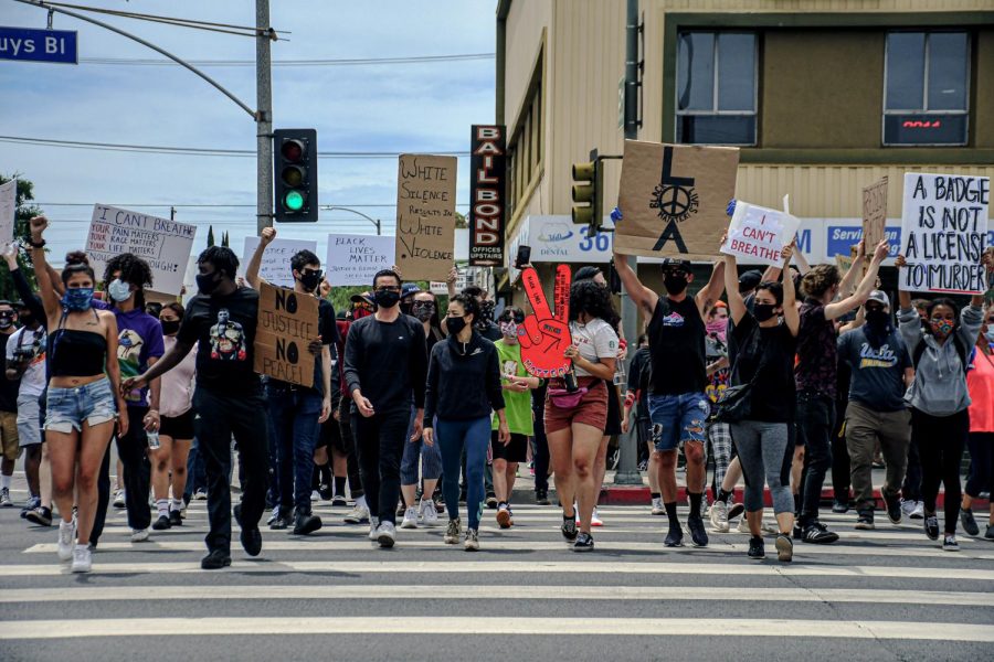 Protestors who converged on the Valley Civic Center cross Van Nuys Blvd. as they prepare to block the street during a protest in support of Black Lives Matter on June 1. A large contingent of LAPD riot control officers were present to protect government offices.