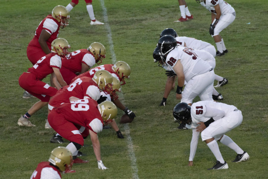  Taft Offensive line prepares to snap the ball to their quarterback against the black and white defenders. The Wolves were unable to contain the offense and lost the game with a final score of 43-6. 