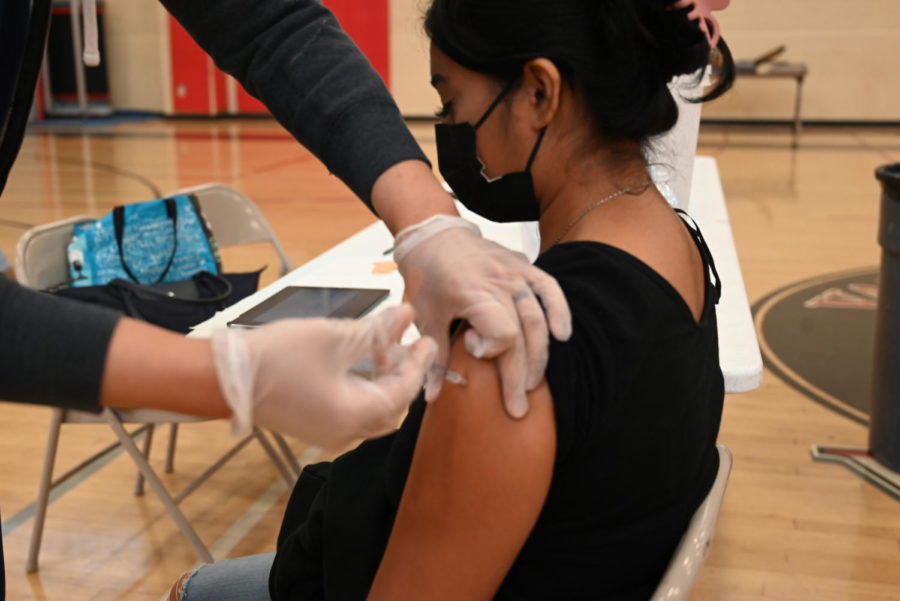 Senior Heidy Rosales-Castillo closes her eyes as she gets her first dose of the covid-19 vaccine on Wednesday, Sept. 29. 