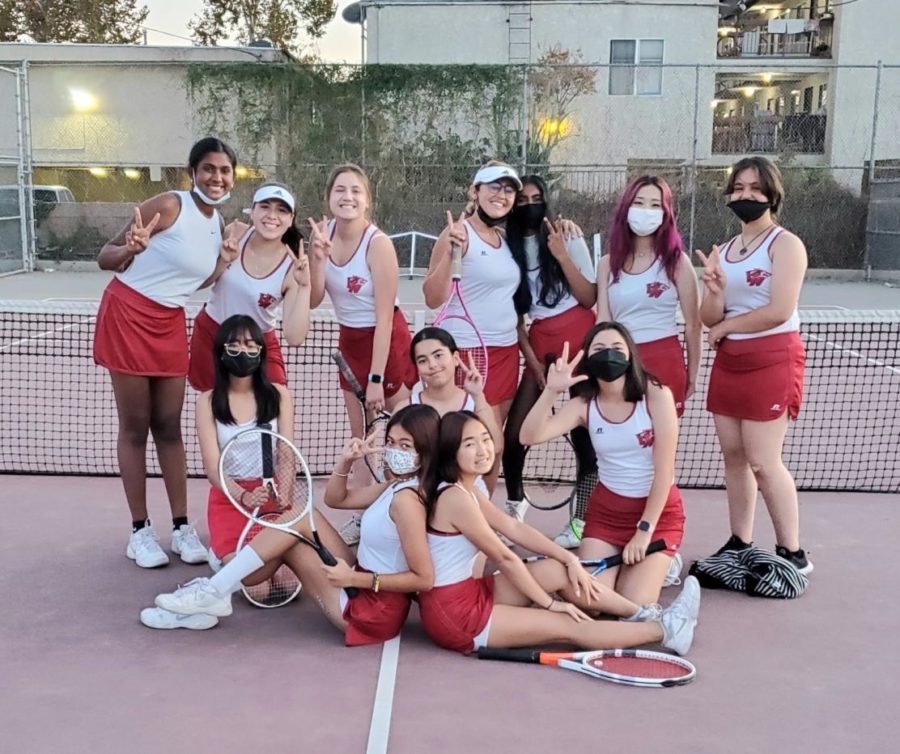 The tennis team poses for a group photo on their home court after a team match. 