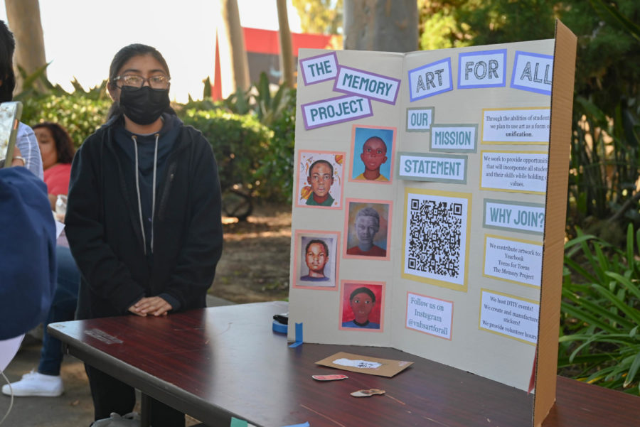  Club President Jersey Vargas stands at the “Art For All” club booth to inform students about the club. 