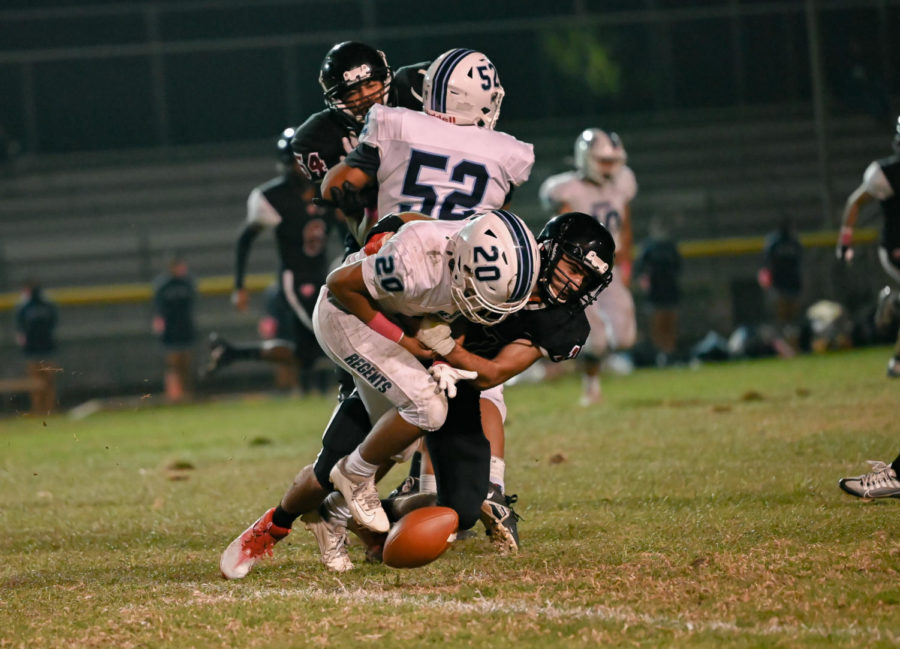 David Terzian (#17) helps hold up the defense line and tackles a Regent before they can advance their position. Their effective defense throughout the game allowed the Wolves to keep the Regents from scoring continuously.
