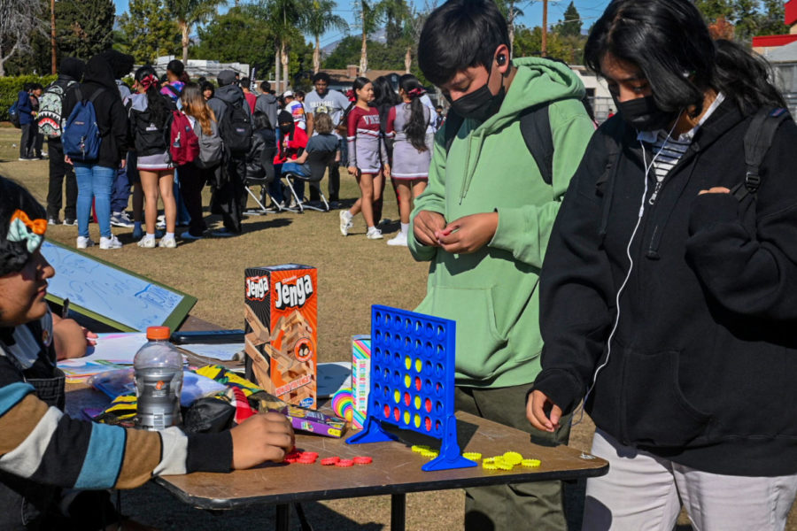 Students line up to play games for Jenga and Connect-Four while competing with others.
