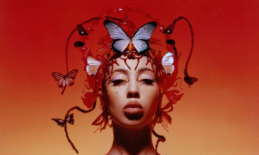 Kali Uchis in her album cover for Red Moon In Venus modeling an array of butterflies.