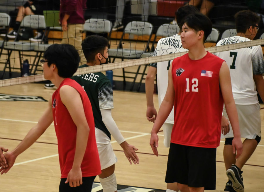 Quanzhen Jiang, #1, and Gambat are high-fiving the other team after the game.  
