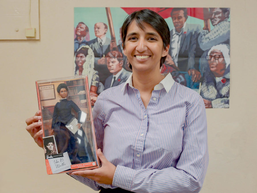 History Teacher Aditi Doshi shares her love of African American history through, decorations, books written by black authors, and merchandise in the likeness of black historical figures. She is seen holding a Barbie doll of Ida B. Wells.
