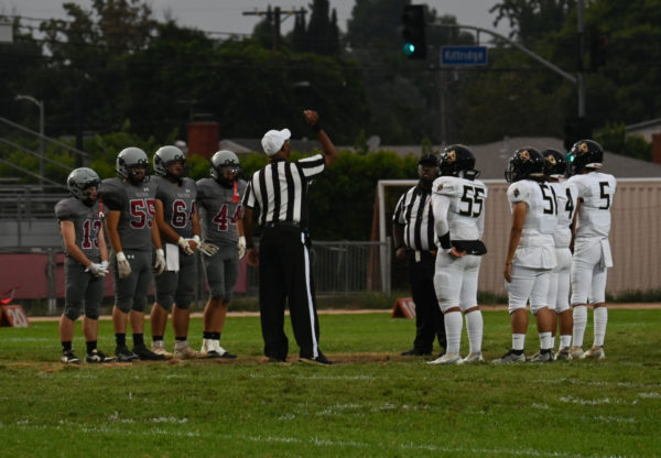 The Van Nuys High School Wolves versus the Panorama High School Pythons flipping the coin to decide who will get possession of the ball and determine the winning team.