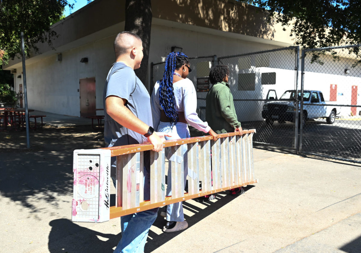 ASB students carry their ladder back to storage after taking down the decorations for Homecoming.