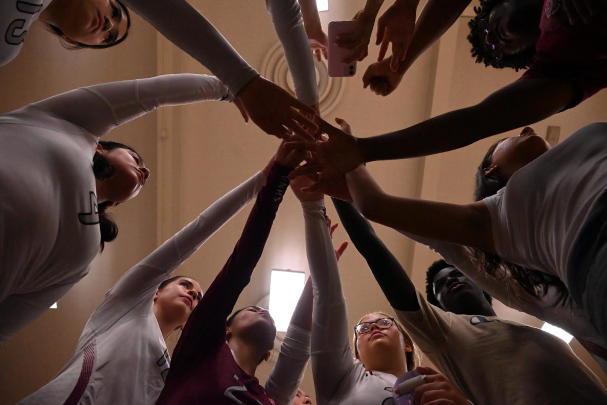 The girls volleyball team rallies together before a game.