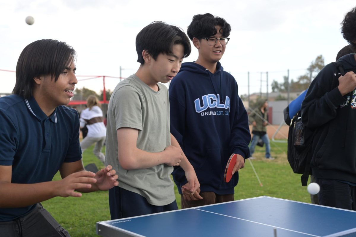 A group of freshman students enjoying playing ping pong in their own way.
