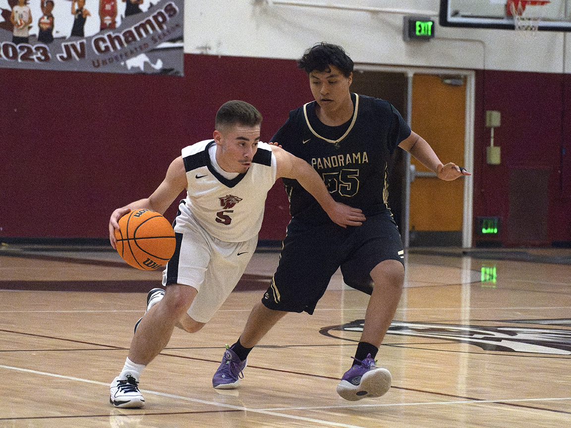Point guard Abraham Ceja (#5) attempts to make a layup under pressure from his San Fernando opponent. The Wolves won the Jan. 17 home match 43-32.