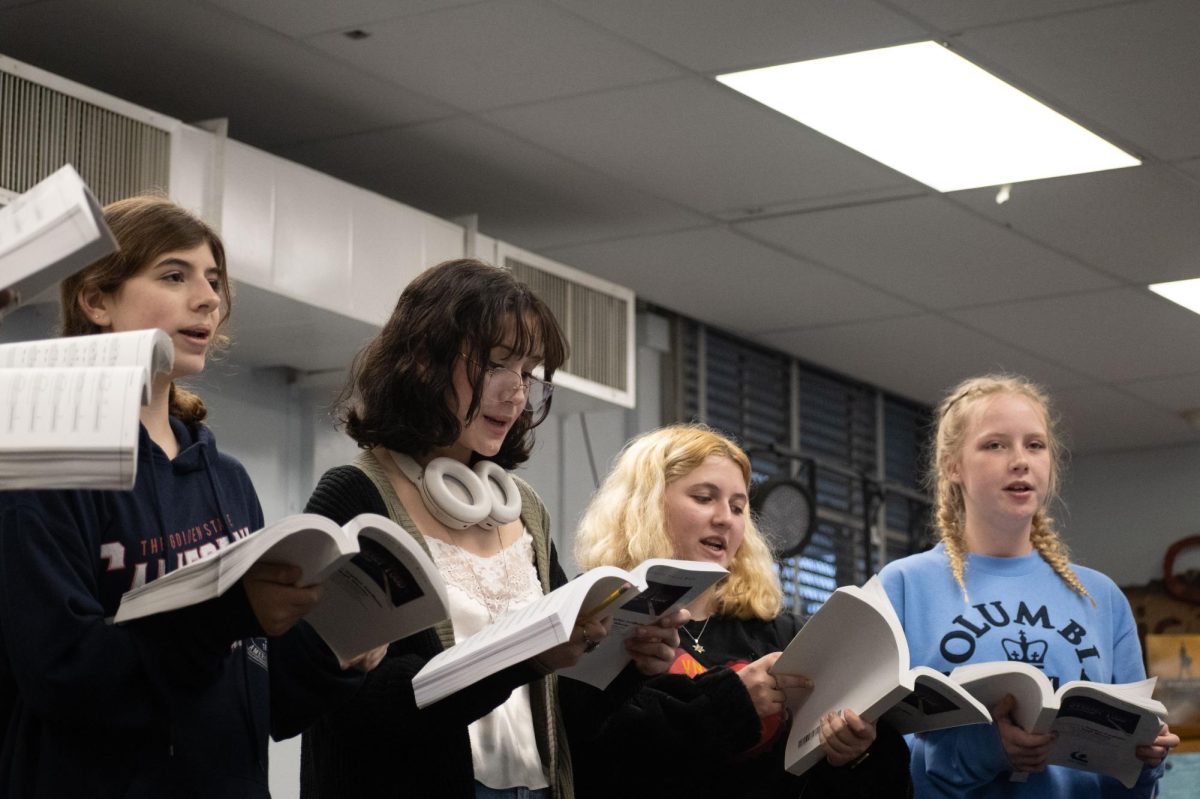 From L to R: Olivia Klipstine, Maddie KC-Jordan, Ami Singer and Ellie Steinberg hold their scripts while singing out loud in rehearsal. 