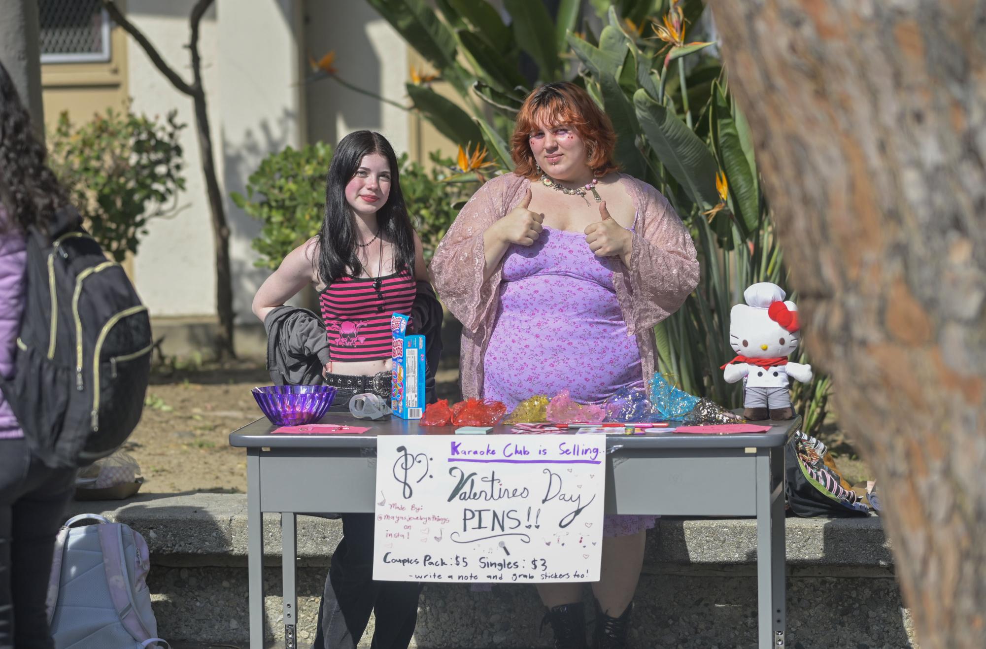 Hanna Berson (L) and Maya Diaz sell Valentines Day pins to promote and fund the Karaoke Club.