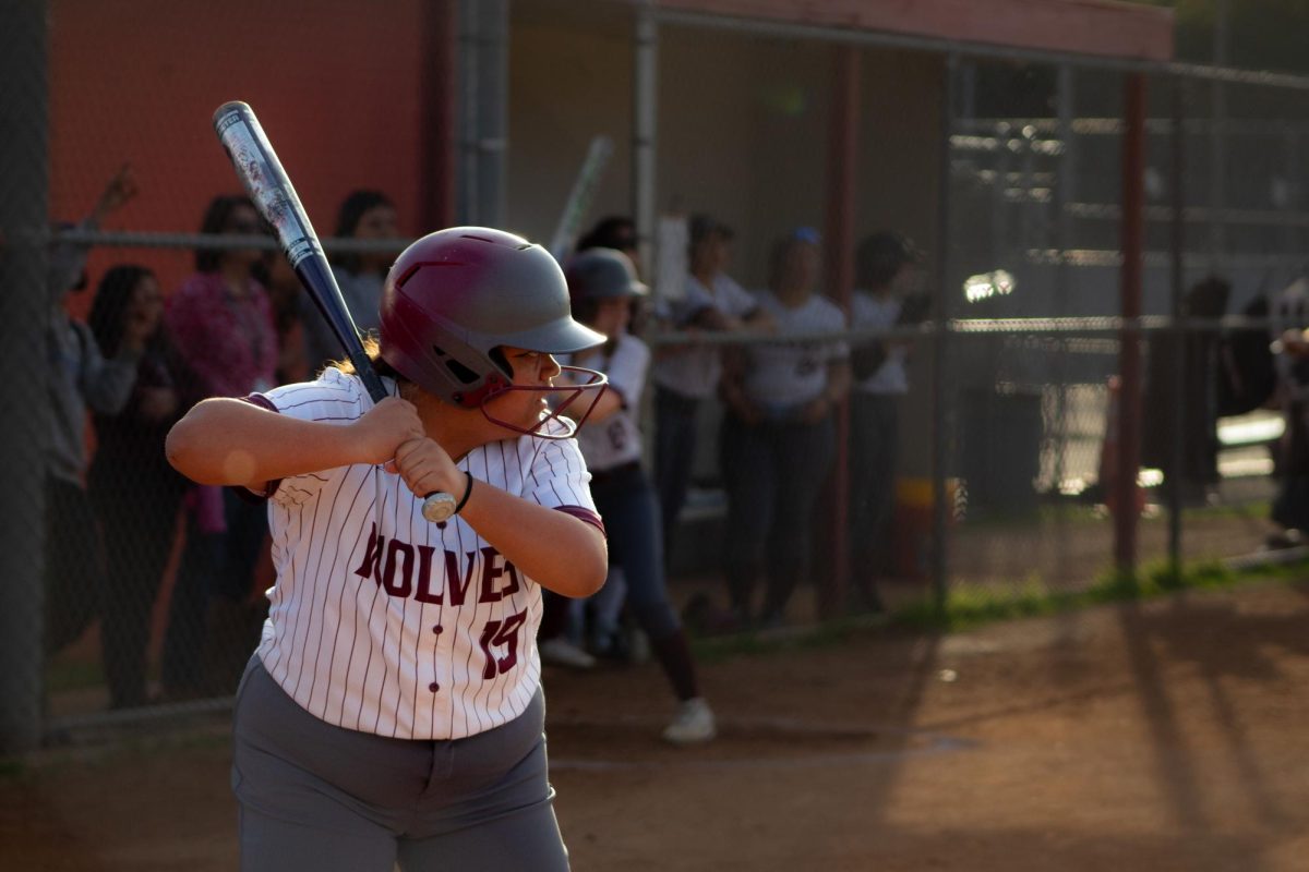 Varsity right fielder Leah Torres glances over at the pitcher from Monroe High School, making a last minute decision as to whether or not she should swing her bat. This was the Wolves' season opener. 