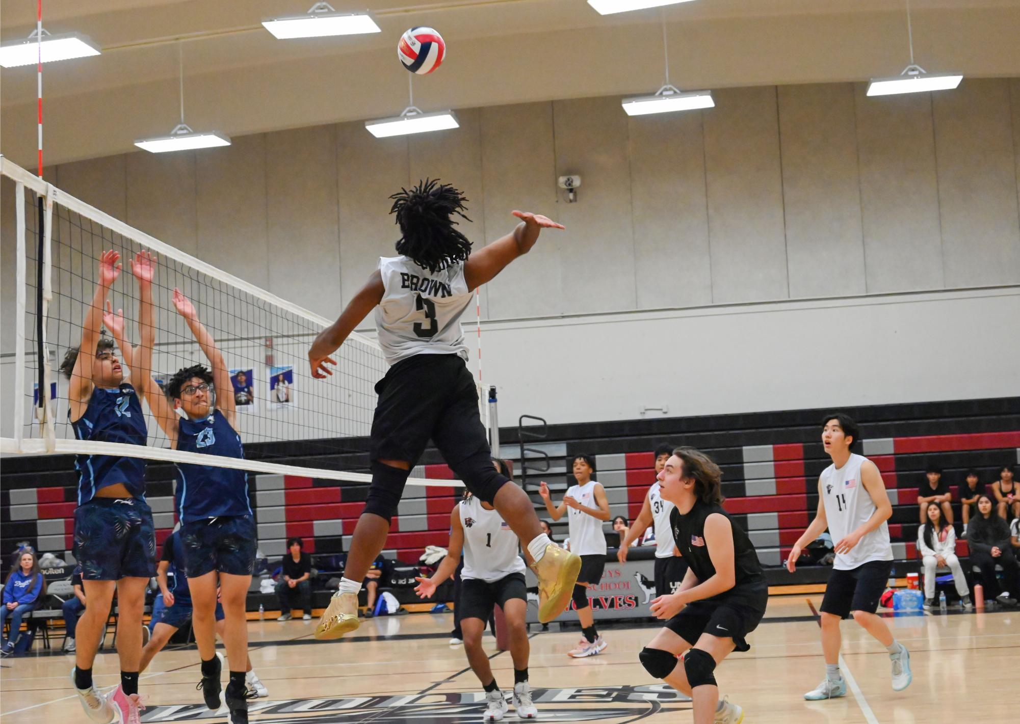 Devin Tanner Brown (#3) spikes the ball over the net for a kill.
