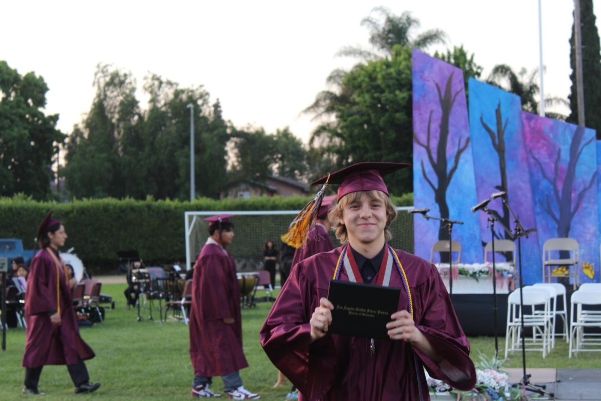 Senior Ethan Rodda excitedly shows off his diploma to the crowd moments after earning it.
