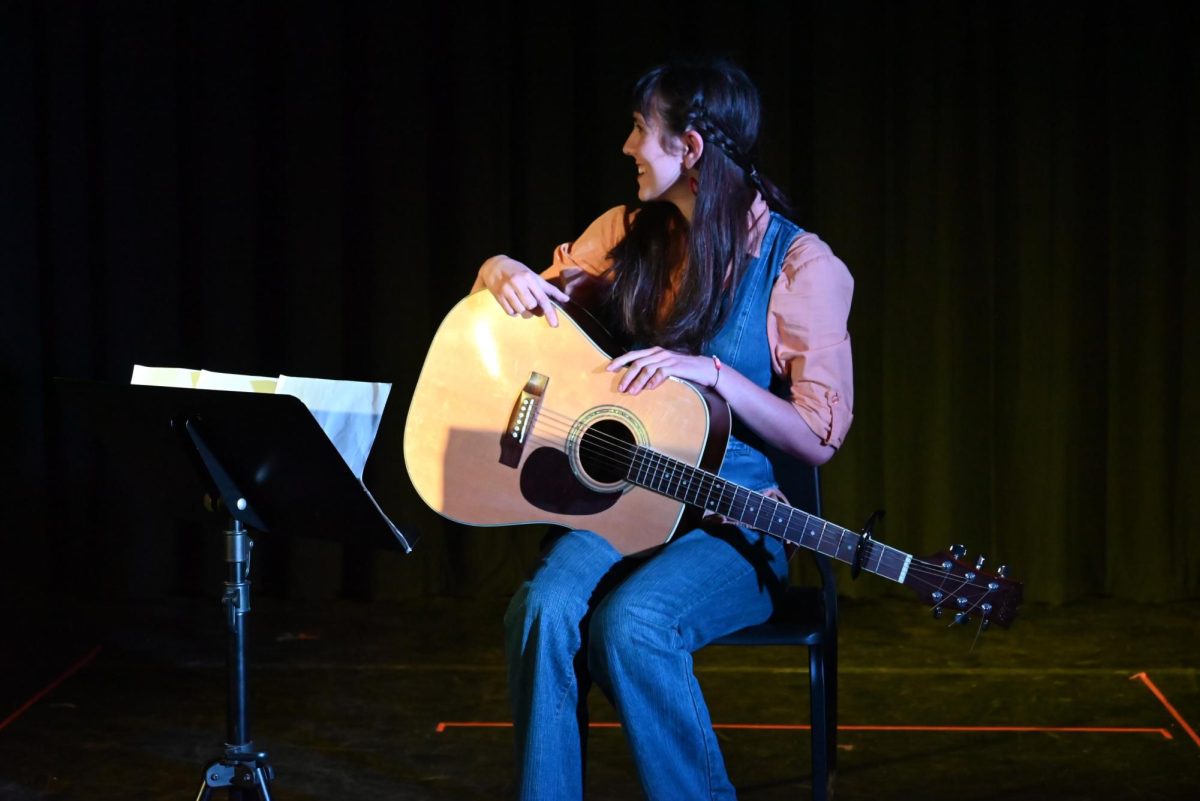 Shows that take place in the blackbox are relaxed, leaving room for error and performer interaction. In a moment of panic, senior Adrianna Bean looks to director Mr. Justin Baldridge for help getting her music back on to the stand