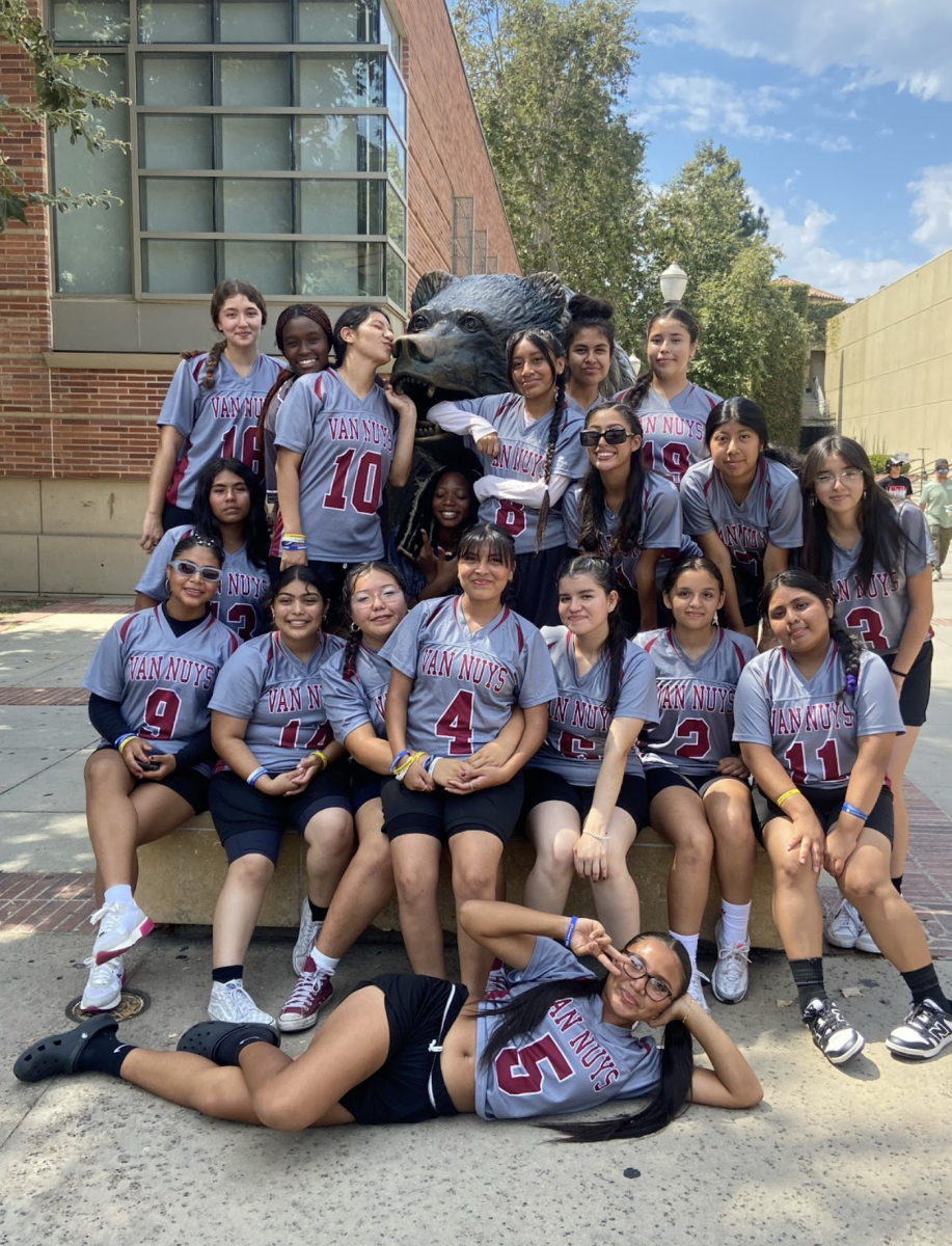 The girls flag football team poses in front of the University of California Los Angeles (UCLA) bruin statue with excitement filling their bodies as they are about to play their first game at the Rams Jamboree. 