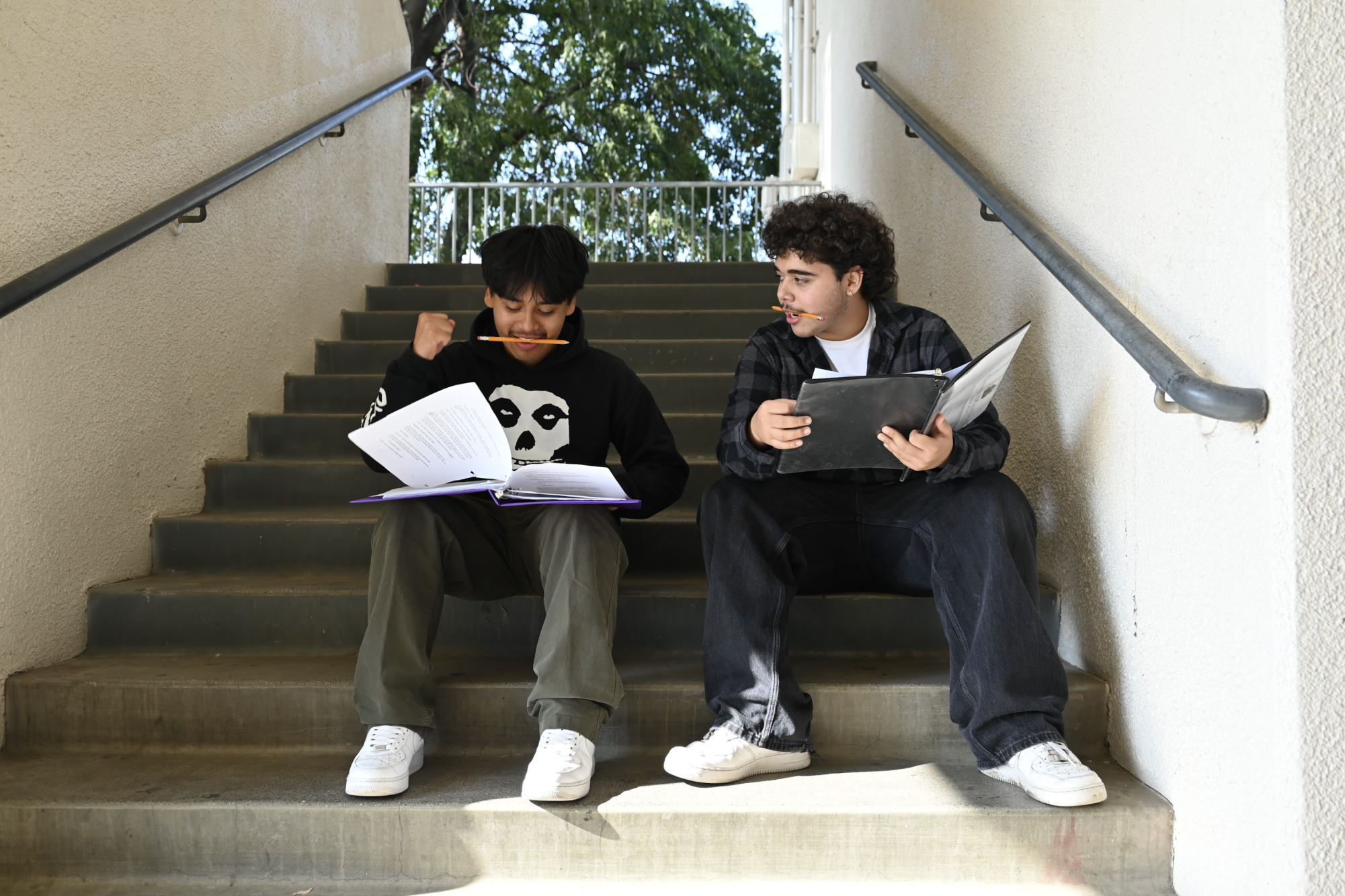 (From L to R) Junior Chris Ruiz and Senior Deven Martinez rehearse outside. Placing pencils in their mouths while they speak, the actors work to improve their diction on stage.