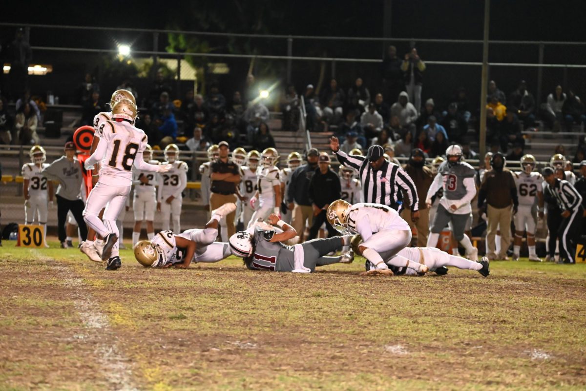 Senior running back Marlon Figueroa gets knocked to the ground by the Kennedy High School Golden Cougars as he gains yardage for the Wolves.