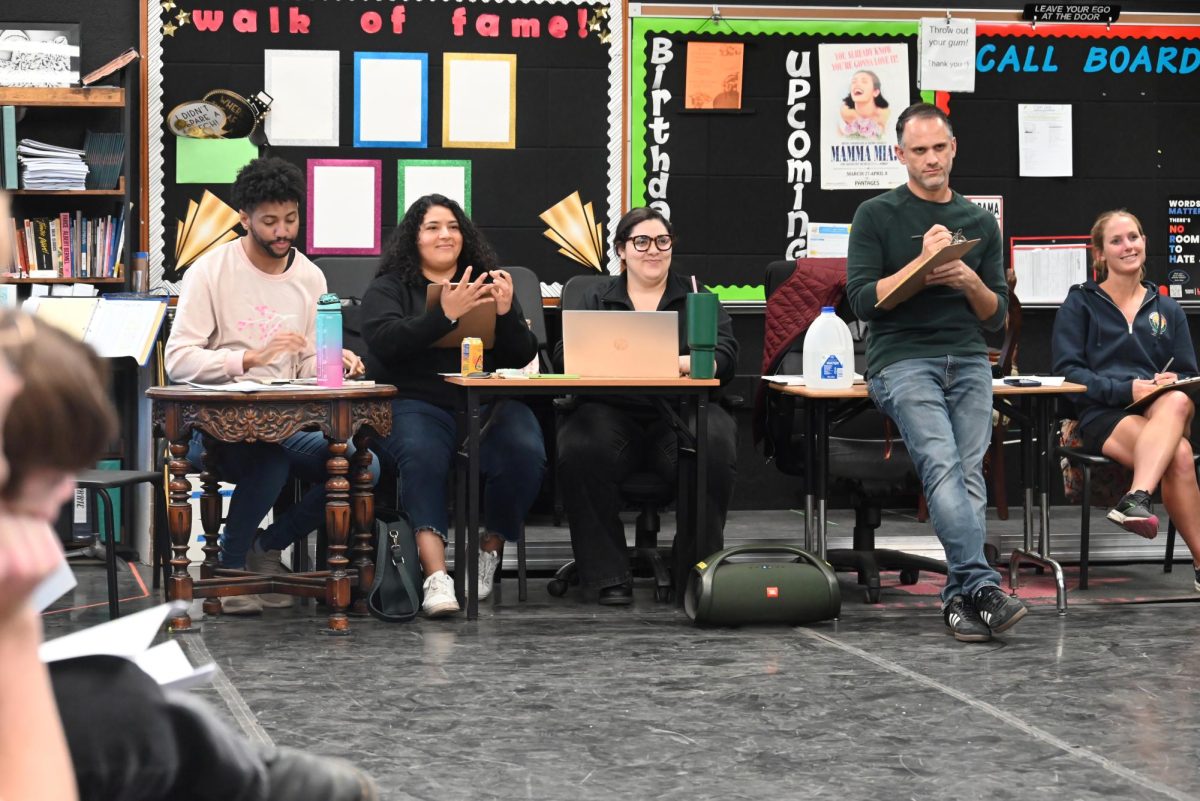 The panel of judges for "Mamma Mia!" watch a group of students auditions, taking every detail of the performance into account