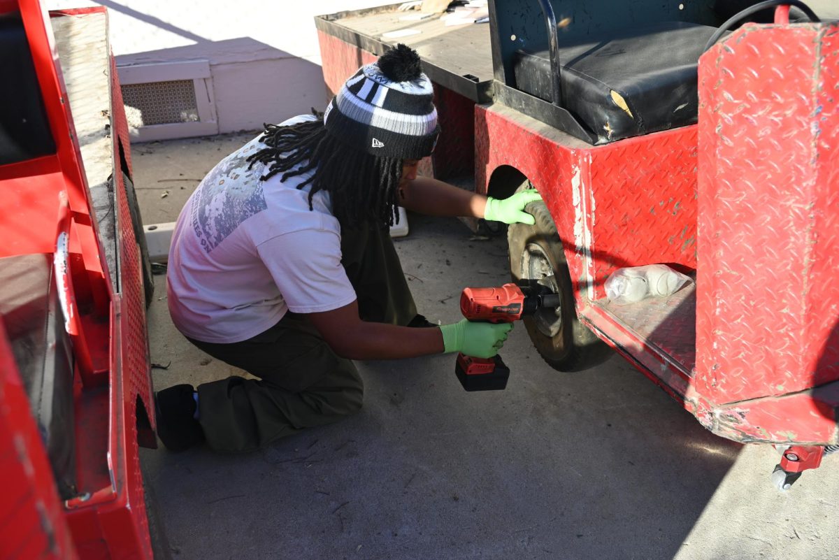 Senior Imani Joseph fixing a golf cart.