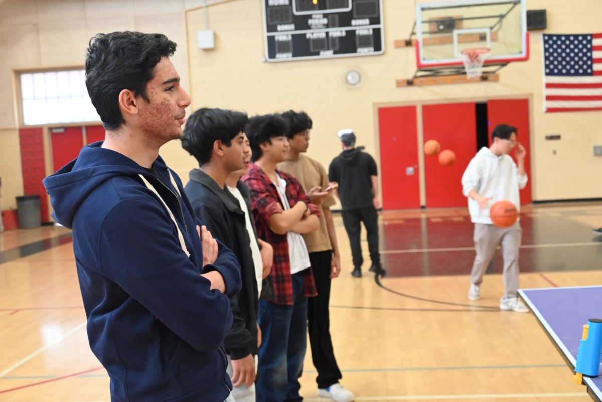 Students from the high school ping pong club gather for a series of exciting matches, with teachers and peers joining in to support and participate in the event.