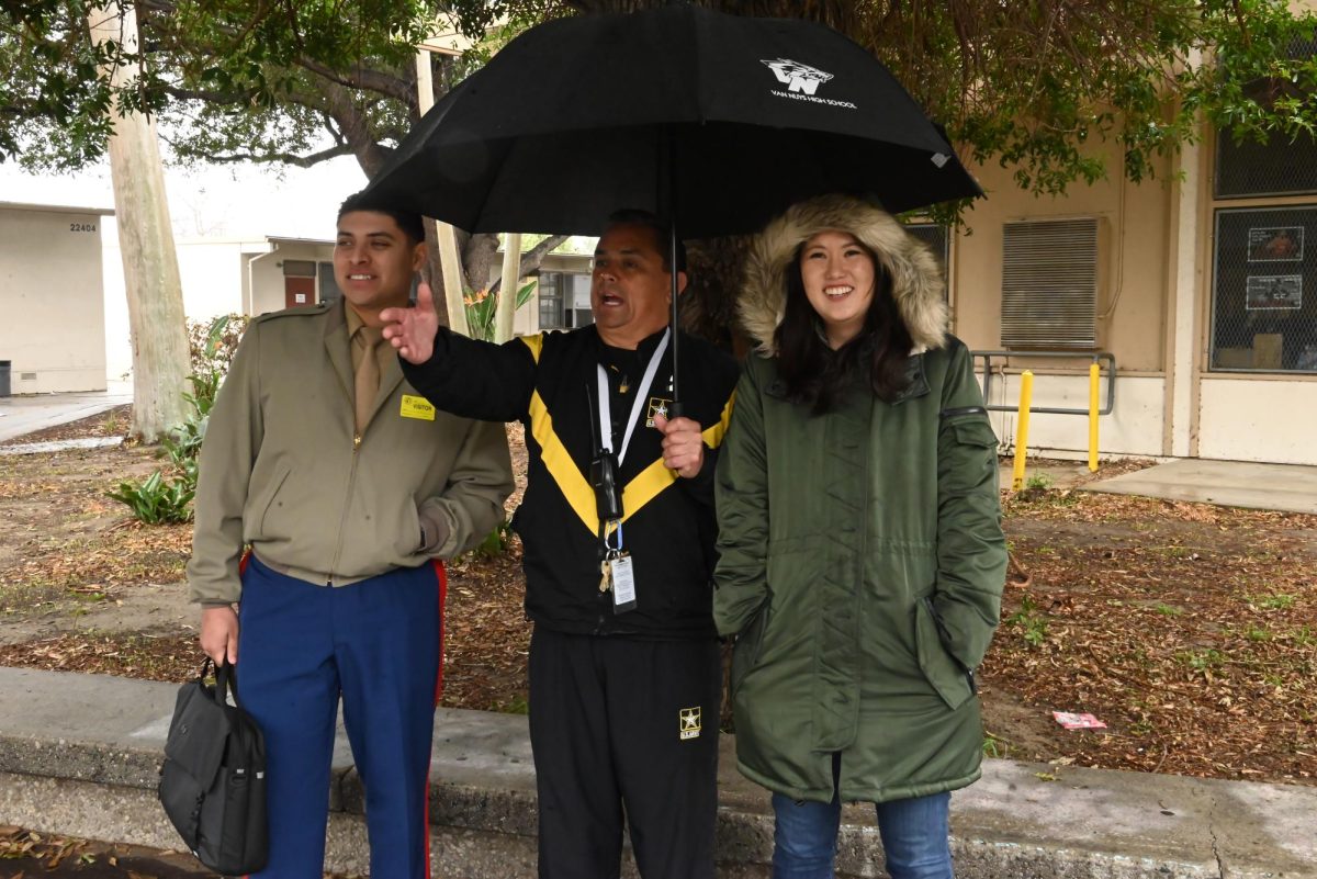 Ms. Park and Sergeant Martinez monitor the lunch lines in the rain.