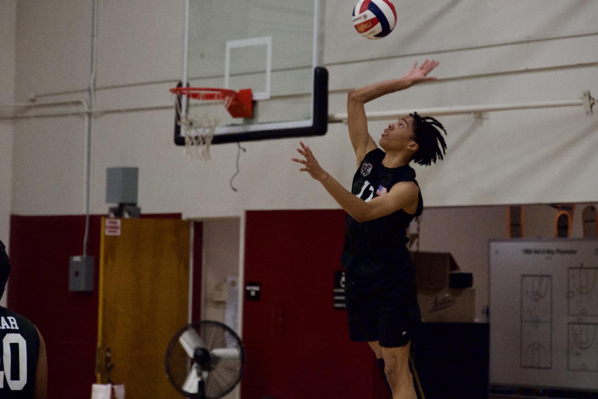 As the whistle blows, junior Aidyn Kinchen tosses up the ball to serve it over.