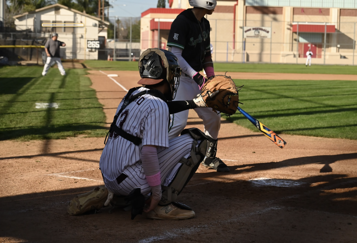 Senior Nate Renard playing catcher position during baseball season game.