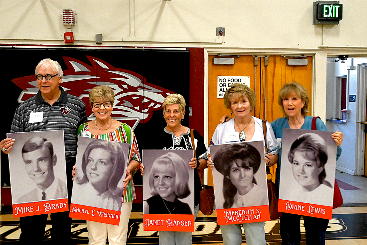 Van Nuys High School class of 1965 alumni stand proudly before their yearbook photos, reliving cherished memories during a heartfelt memorial event hosted by ASB. THE MIRROR | MELOS SERA