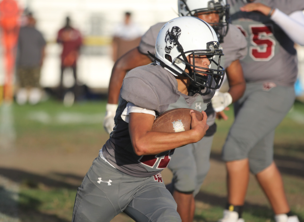  TACKLING NEW CHALLENGES | Junior David Velasquez dodges tackles as he joins the varsity foot- ball team for the first time ever.