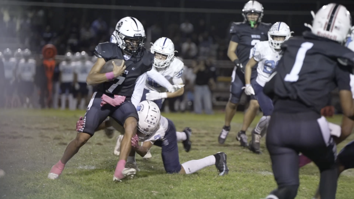  Pushing Through  Senior quarterback Carlos Herrera weaves through opponents as he runs down the field. 