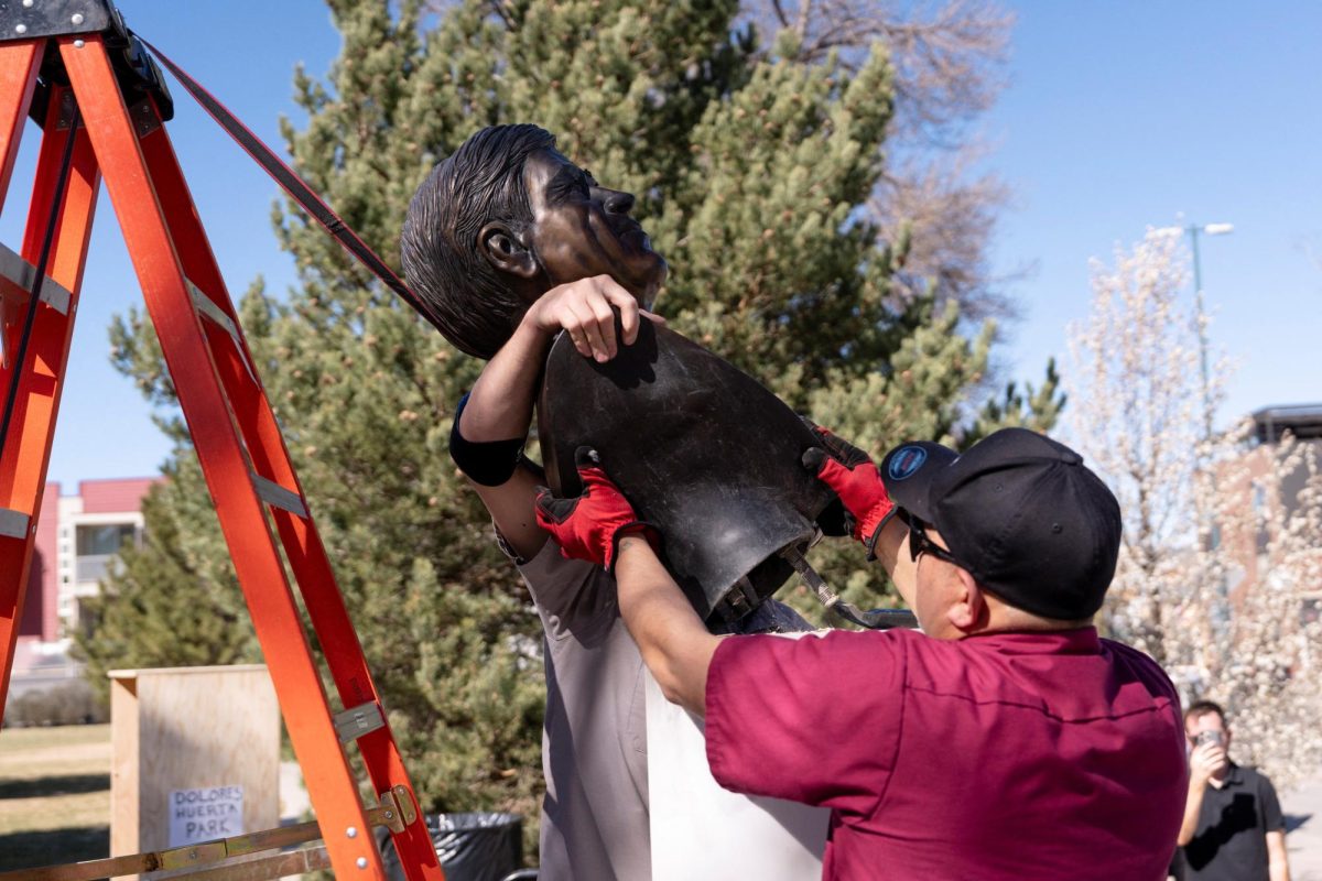 Facilities workers with Denver Arts and Venues prepare to pull down a bust of United Farm Workers union co-founder Cesar Chavez, after civil rights leader Dolores Huerta accused Chavez of sexually assaulting her in the 1960s, at Cesar Chavez Park in Denver, Colorado, U.S., March 19, 2026.   REUTERS/Cheney Orr