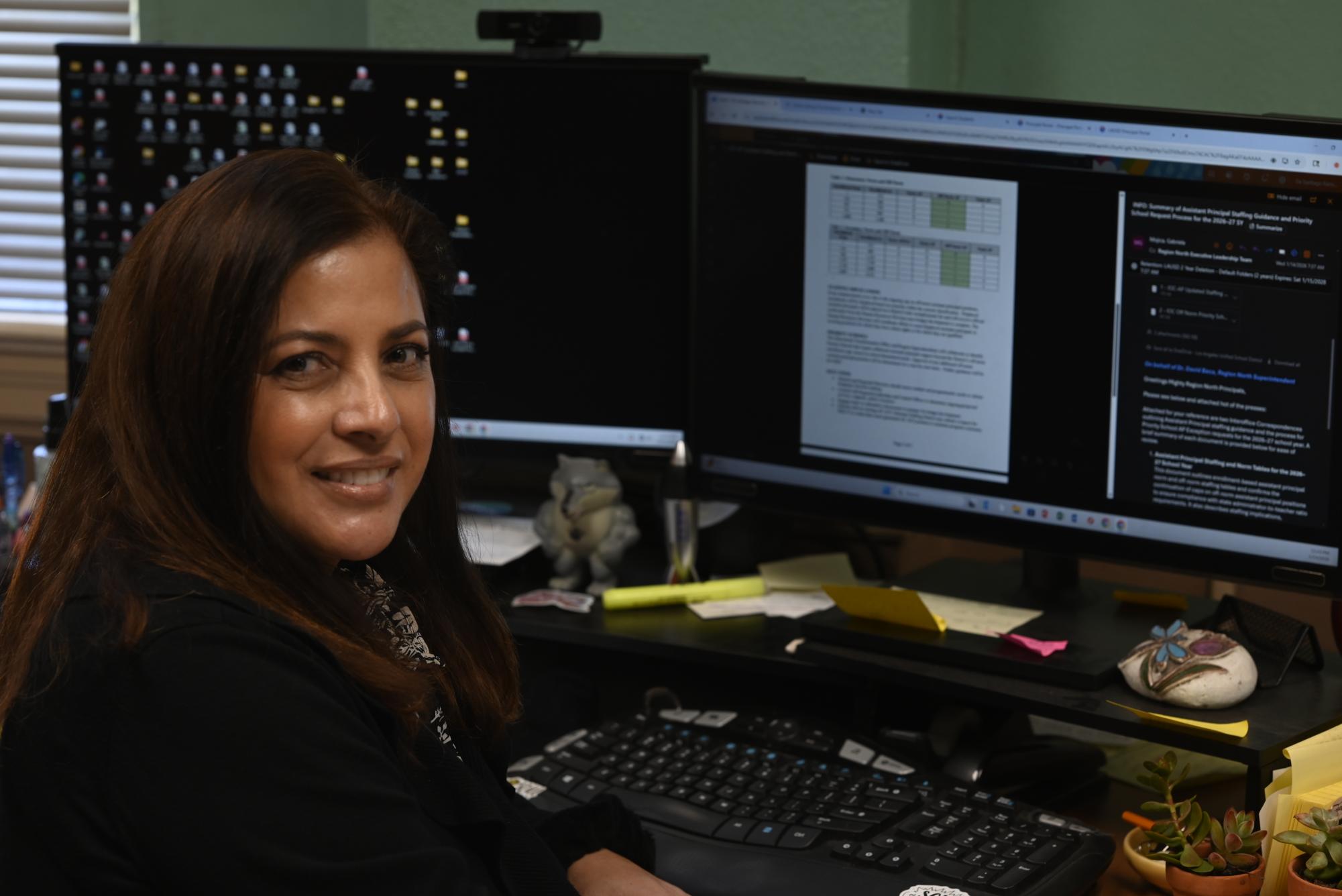  SHAPING STUDENTS TO SUCCEED  Principal Lourdes DeSantiago sits at her desk reading emails. DeSantiago, who has led the school since 2021, oversees a campus of programs she has expanded or created, including one of only three International Newcomer Academies in LAUSD.
